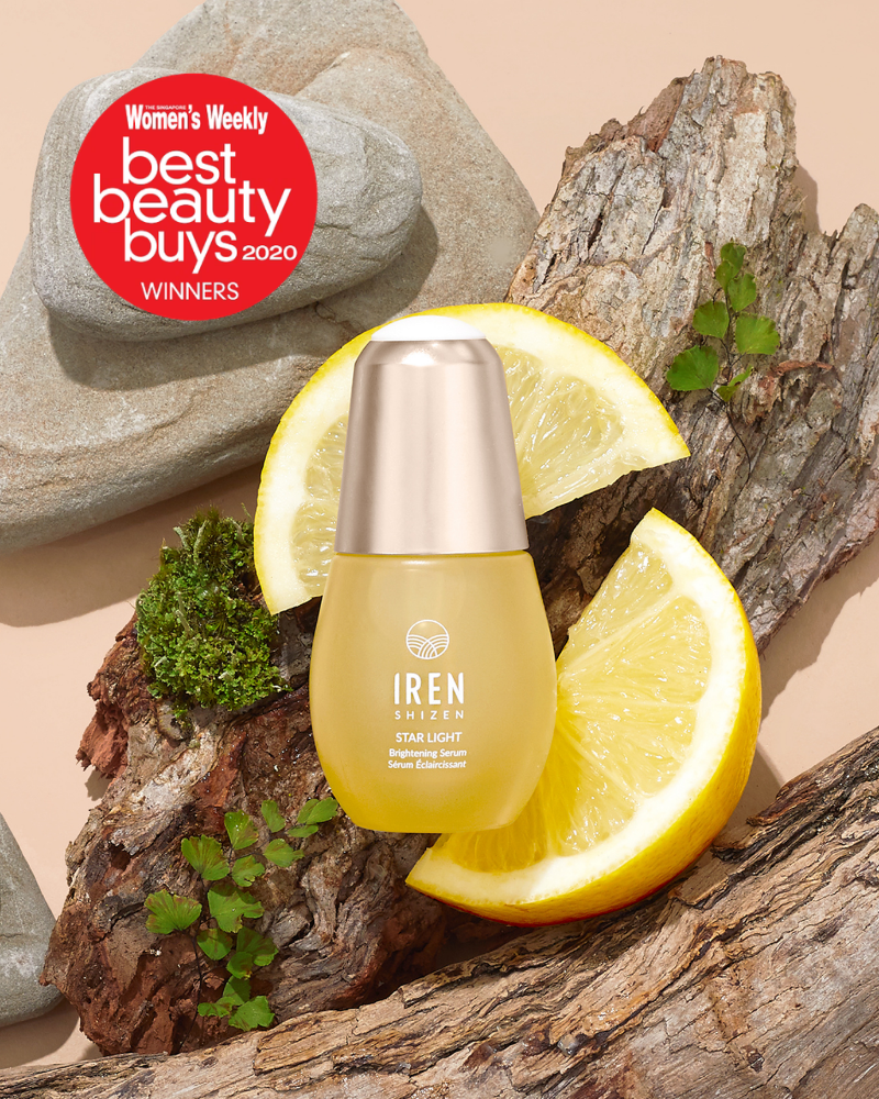 A bottle of STAR LIGHT Brightening Serum by IREN Shizen is shown on wood with lemon slices and rocks, next to a red “Women’s Weekly Best Beauty Buys 2020 Winners” badge—ideal for targeting hyperpigmentation and dark spots.