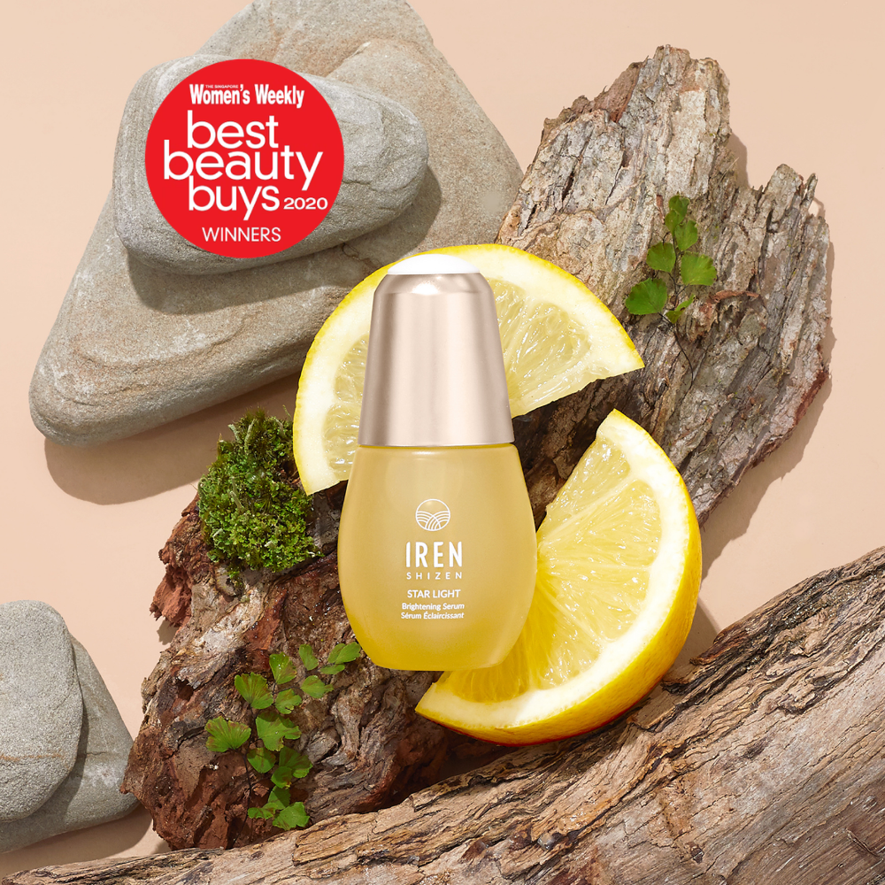 A bottle of STAR LIGHT Brightening Serum by IREN Shizen is shown on wood with lemon slices and rocks, next to a red “Women’s Weekly Best Beauty Buys 2020 Winners” badge—ideal for targeting hyperpigmentation and dark spots.