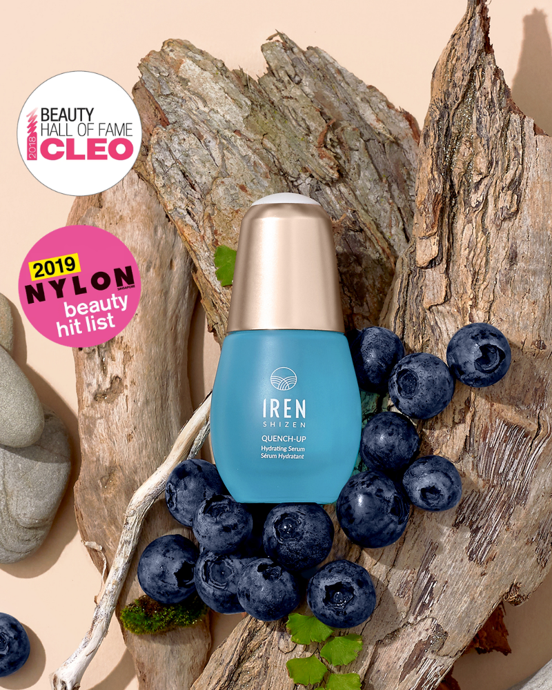 A blue QUENCH-UP Hydrating Serum bottle by IREN Shizen is surrounded by blueberries, driftwood, stones, and CLEO and NYLON award stickers—ideal for plump skin with Hyaluronic Acid.
#all-groups