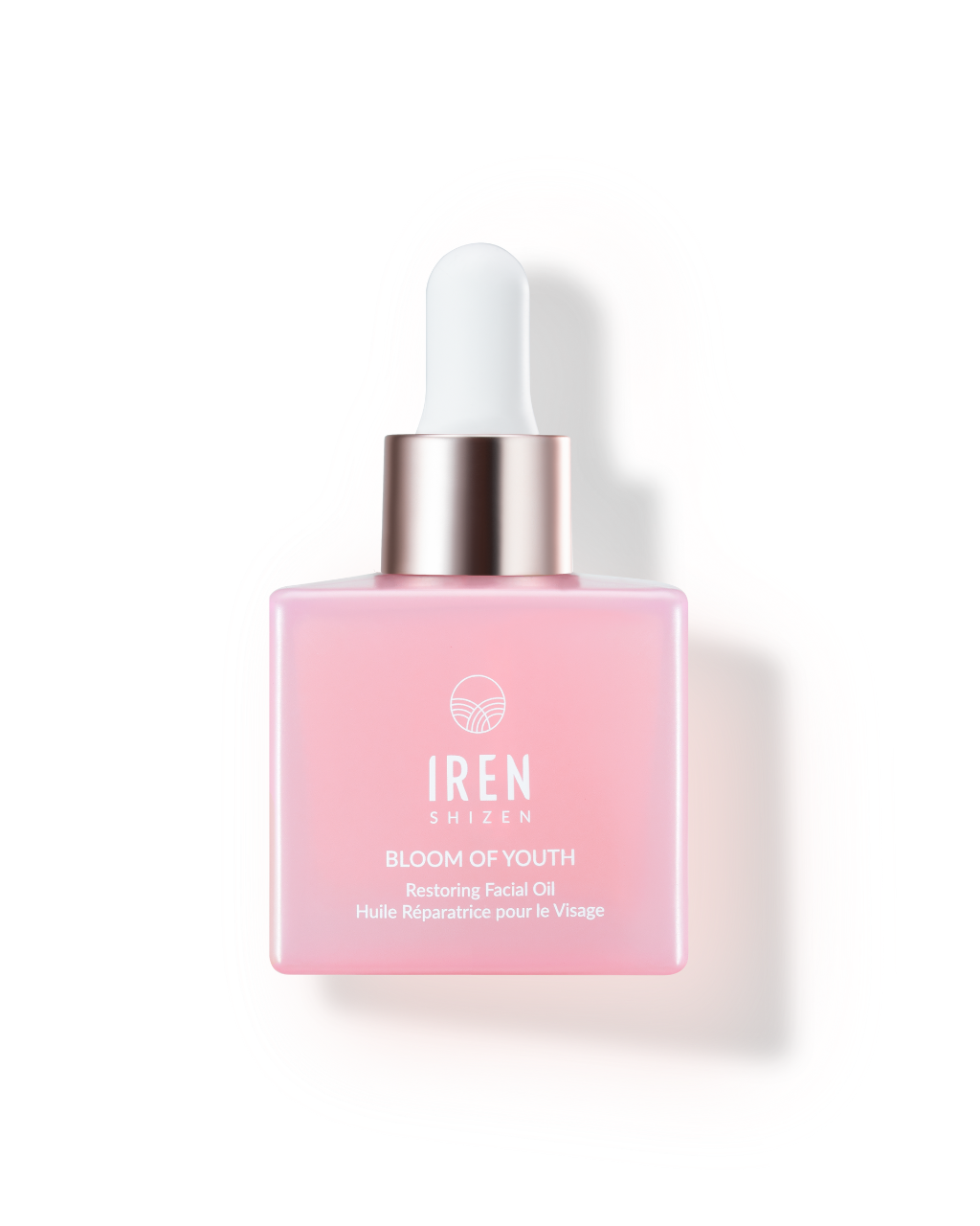 A pink lightweight BLOOM OF YOUTH Restoring Facial Oil bottle with a dropper, floating against a matching swatch-background by IREN Shizen.