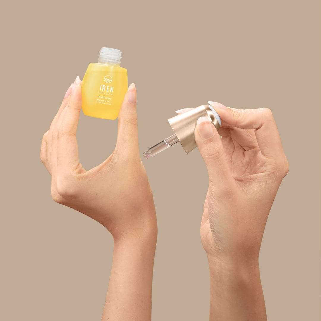A woman's hands holding a small bottle of customised IREN Shizen STAR LIGHT Brightening Serum. #all-groups