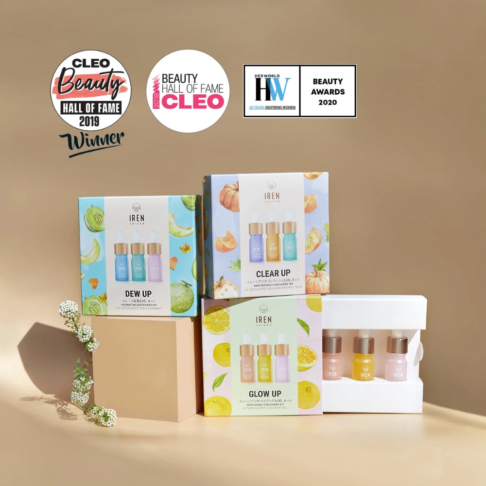 Three CLEAR UP Anti-Blemish Discovery Kits by IREN Shizen and a white tray of mini serums with Japanese superfruits are displayed on beige, with three beauty award badges above.