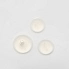 Three small, clear liquid droplets on a plain white surface, possibly from the LIFT & FIRM Anti-Aging Duo Serum Set by IREN Shizen, which contains Argireline Peptide. #all-groups